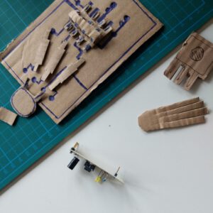 foto showing a paper prototype for a PCB, with several electronic building parts and drawings for the connections